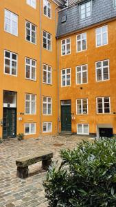 un edificio arancione con una panca davanti di ApartmentInCopenhagen Apartment 1580 a Copenaghen