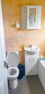 a bathroom with a white toilet and a sink at Cosy Single Room in Redditch: Free Parking/Wi-fi in Headless Cross