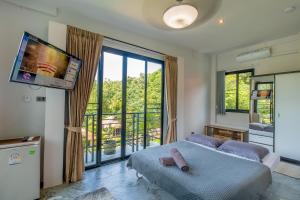 a bedroom with a bed and a flat screen tv at Penthouse Crystal Bay Apartments in Ban Lamai