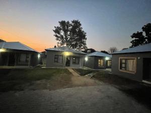 une maison éclairée dans la cour la nuit dans l'établissement Masana at Homely Escape, à Phalaborwa