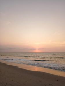 una playa con puesta de sol sobre el océano en HospedajesPerú en Zorritos