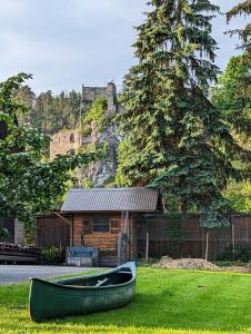 a green boat sitting in the grass in front of a house at Frühstückspension Eibenstein 