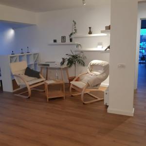 a living room with two chairs and a table at Penthouse View 29 in Piteşti