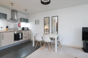 cocina con mesa y sillas en una habitación en City Stay Apartments - Vizion, en Milton Keynes