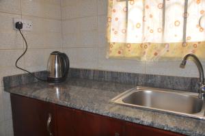 a kitchen counter with a sink and a window at Malaika Furnished Apartments in Kampala