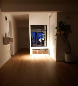 an empty living room with a window and a plant at Penthouse View 29 in Piteşti
