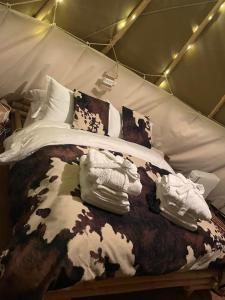Una cama en una tienda con calcetines y zapatos. en Burtree Country House and Retreats Tipi en Thirkleby
