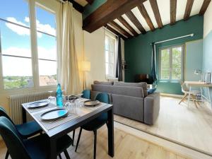a living room with a table and a couch at L'Horizon - Entrée indépendante - Parking in Chartres