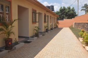 a brick walkway next to a building with potted plants at Malaika Furnished Apartments in Kampala