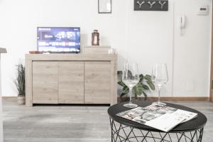 uma mesa com dois copos de vinho e uma televisão em Ca' Latina - Cozy home in pieno centro storico em Treviso