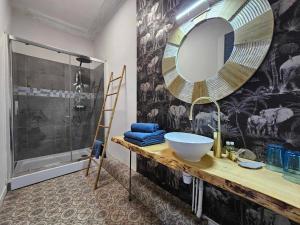 La salle de bains est pourvue d'un lavabo, d'un miroir et d'une douche. dans l'établissement Bastide du Thoré, à Labastide-Rouairoux