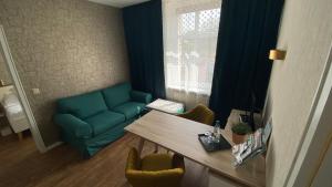 a living room with a blue couch and a table at APARTHOTEL 1A in Zwickau