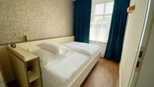 ein kleines Bett in einem Zimmer mit Fenster in der Unterkunft APARTHOTEL 1A in Zwickau