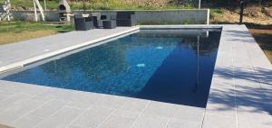 a swimming pool with blue water in a backyard at La Villetta Relais Luxury in Marina dʼAvola