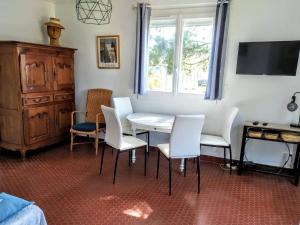 ein Esszimmer mit einem Tisch und Stühlen sowie einem TV in der Unterkunft Maison Noirmoutier-en-l'Île, 3 pièces, 4 personnes - FR-1-224B-90 in Noirmoutier-en-l'lle