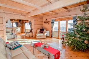 a living room with a christmas tree in the corner at Domek u Horarów in Ciche