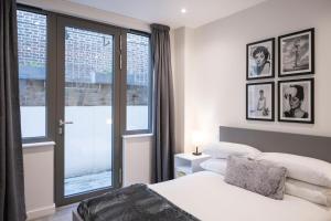 1 dormitorio con 2 camas y ventana en Newly Furnished Apt w/ Patios - Hampstead Heath en Londres