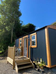 a tiny house with a wooden porch and a bench at Shepherds Hut near Gortin Omagh in Omagh