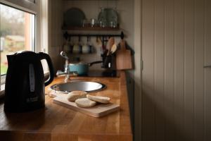 a kitchen counter with a coffee maker and cookies on a cutting board at Shepherds Hut near Gortin Omagh in Omagh