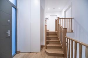 una escalera en una casa con paredes blancas y suelo de madera en Newly Furnished Apt w/ Patios - Hampstead Heath en Londres