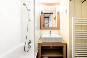 a bathroom with a white sink and a shower at Location Appartement Arzon (56640) 4 personnes in Arzon