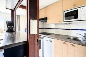 a kitchen with a sink and a microwave at Location Appartement Arzon (56640) 4 personnes in Arzon +21 photos
