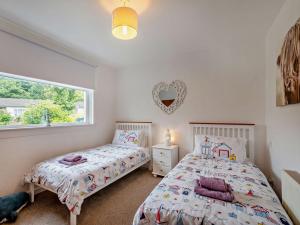 a bedroom with two beds and a window at 3 Bed in Lamlash CA354 in Lamlash