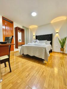 een grote slaapkamer met een bed en een bureau bij Jultom Inn Hotel & Suites in Trujillo