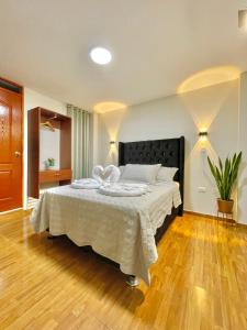 een slaapkamer met een groot bed met een zwart hoofdeinde bij Jultom Inn Hotel & Suites in Trujillo