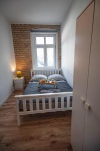 a bedroom with a bed in a room with a window at apartament Rynek in Leśna