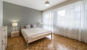 a bedroom with a bed and a large window at Athénée 36 Résidence by Homenhancement in Geneva