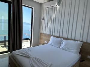 sypialnia z łóżkiem i widokiem na ocean w obiekcie Villa Xhefri 2 w Sarandzie