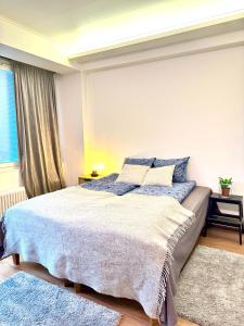 a bedroom with a large bed with blue pillows at Turku Central Luxury Modern Cozy Flat 69m2 in Turku