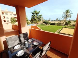 d'une table et de chaises sur un balcon avec vue sur la cour. dans l'établissement La Serena Apartment - 3310, à Los Alcázares