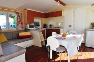 - une cuisine et une salle à manger avec une table et des chaises dans l'établissement Camping La Touesse, à Saint-Lunaire