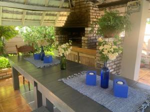 una mesa larga con jarrones azules encima en Bougain Villa BnB en Polokwane