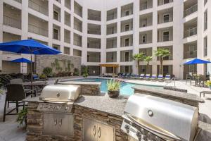 a hotel patio with a grill and a swimming pool at League Flats South End on South College Street in Charlotte