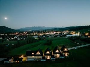 - un groupe de cottages sur un parcours de golf la nuit dans l'établissement Mleko domki, à Białka Tatrzańska