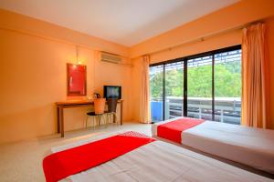 a bedroom with two beds and a large window at OYO 1148 Aonang Andaman Resort in Ao Nang Beach
