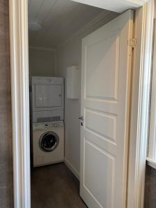a laundry room with a washing machine and a door at Adventure Guesthouse Sweden in rural area Sunne in Sunne