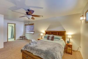 1 dormitorio con 1 cama y ventilador de techo en Wasilla Spruce Moose Cabin Lakefront and Hot Tub!, en Wasilla