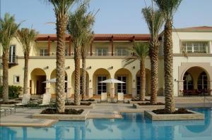 un complexe avec des palmiers et une piscine dans l'établissement Frank Porter - Al Badia 2, à Dubaï