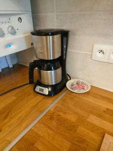 a coffee maker sitting on top of a wooden floor at Le Relais St Georges in Viroflay