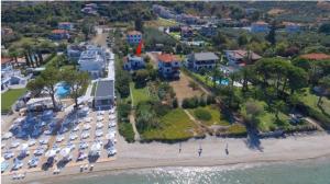 Beach Front Villa in Polychrono في هانيوتي: اطلالة جوية على شاطئ به الكثير من السيارات المركونه