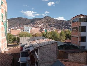 uitzicht op een stad met bergen op de achtergrond bij Posada de Mama in Cuzco