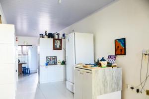 a kitchen with white cabinets and a refrigerator at Casa em Maracajaú in Maracajaú