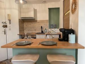 a kitchen counter with two sinks and two chairs at Le Cocon - Parking - Hyper Center in Chartres