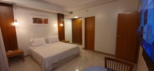 Cobertura Presidencial Tropical Hotel في ماناوس: غرفة نوم صغيرة مع سرير في غرفة