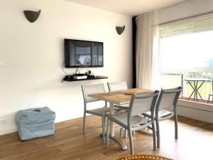 a dining room with a table and chairs and a tv at Appartement 3* avec terrasse et parking, à 2 pas de la plage de Trestraou à Perros-Guirec - FR-1-368-244 in Perros-Guirec