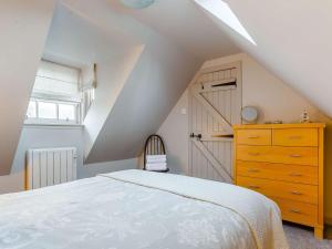 a attic bedroom with a bed and a wooden dresser at 1 bed in Cullen 43628 in Cullen